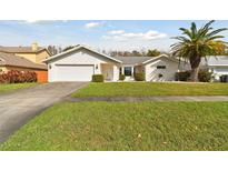 Charming single-story home with a well-manicured lawn, two car garage, and a beautiful palm tree at 4735 Foxshire Cir, Tampa, FL 33624