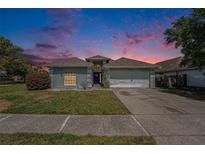 Charming single-Gathering home featuring a well-maintained lawn, driveway, and two-car garage under a lovely sky at 8941 Southbay Dr, Tampa, FL 33615