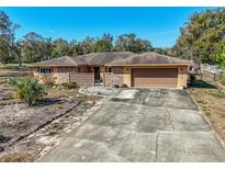 Charming single-story home with a two-car garage and a well-kept front yard at 12111 Scott Dr, Dade City, FL 33525