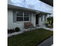 Charming front entrance featuring a cozy bench, well-kept lawn, and decorative stone accents at 2233 Greenhaven Dr # 363, Sun City Center, FL 33573