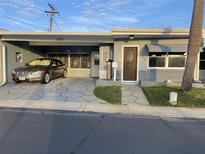 Charming home featuring a covered carport, well-manicured lawn, and inviting front entrance at 250 Rosery Nw Rd # 220, Largo, FL 33770