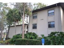 Apartment building exterior with lush, well-maintained landscaping and visible unit number at 3399 Mermoor Dr # 110, Palm Harbor, FL 34685