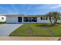 Charming single-story home with a well-maintained lawn, fresh gray paint, and a new driveway at 3550 100Th N Pl, Pinellas Park, FL 33782