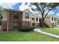 Brick and siding condo building with manicured lawn, mature tree, and inviting walkways at 8642 Mallard Reserve Dr # 203, Tampa, FL 33614