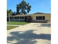 Charming single-story home featuring a well-manicured lawn and a welcoming covered porch with white picket fence at 1149 6Th Ne Ave, Largo, FL 33770