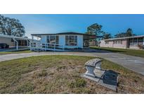 Charming single-story home featuring covered parking, a ramp, and a lovely front bench at 196 Philadelphia Blvd # 10, Palm Harbor, FL 34684