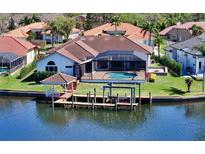 Waterfront home featuring a private dock, pool, and screened-in lanai, perfect for outdoor living at 6014 Mariners Watch Dr, Tampa, FL 33615
