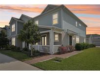 Charming two-story home with manicured lawn and inviting front porch at sunset at 6251 Camino Dr, Apollo Beach, FL 33572