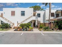 Bright condo complex featuring white stucco, wood trim, colorful landscaping, and convenient parking at 127 Tidewater Dr # 127, Bradenton, FL 34210