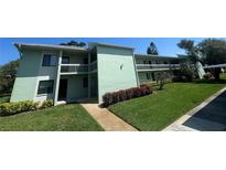 Condominium exterior showcasing well-maintained lawns and mature landscaping at 128 Nancy Dr # 128, Oldsmar, FL 34677