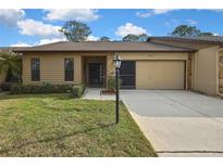 Charming single-story home showcasing a manicured lawn, quaint landscaping, and a welcoming facade at 2224 Vista Royal Way, Spring Hill, FL 34606