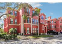Charming red condo building with well-maintained landscaping and convenient attached garages at 2713 Via Murano # 216, Clearwater, FL 33764