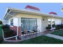Charming condo featuring a cozy front porch with seating and well-maintained landscaping at 4355 Tahitian Gardens Cir # D, Holiday, FL 34691