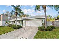 Inviting one-story home with two-car garage, mature landscaping, and a well-maintained lawn at 45 Gulfwinds W Dr, Palm Harbor, FL 34683