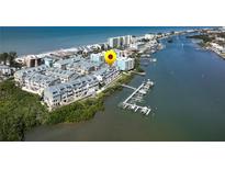 Aerial view showcases waterfront townhomes, boat docks, and proximity to the beach and Intracoastal Waterway at 19915 Gulf Blvd # 704, Indian Shores, FL 33785