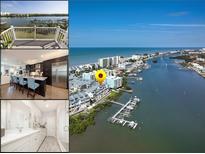 Beautiful aerial view of waterfront homes and docks on a sunny day with a blue sky and water at 19915 Gulf Blvd # 704, Indian Shores, FL 33785
