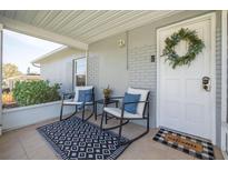 Inviting front porch features seating, a welcome mat, and a decorative wreath on the white front door at 305 6Th Sw Ave, Largo, FL 33770