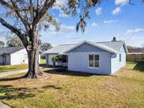 Charming single-story home with a blue exterior, well-maintained lawn, and mature trees at 3426 Monte Rio St, New Port Richey, FL 34655