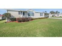 Charming home featuring a well maintained lawn, cozy entryway, and manicured shrubbery at 37508 Gill Ave, Zephyrhills, FL 33541