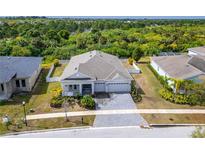 Beautiful aerial view of single-story home with lush landscaping and gray brick driveway at 618 Manns Harbor Dr, Apollo Beach, FL 33572