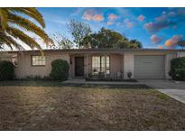 Charming single-Gathering home with a stone-accented facade, front patio, and an attached garage at 6840 Mesa Verde St, Port Richey, FL 34668