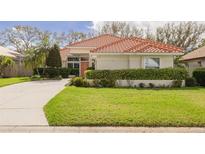 Charming single story home with lush green lawn and a red tile roof at 872 Live Oak Ne Ter, St Petersburg, FL 33703