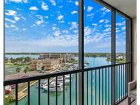 Expansive balcony view of the marina and waterfront from this condo, featuring a black metal railing and bright skies at 10355 Paradise Blvd # 909, Treasure Island, FL 33706