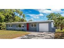 Charming single-story home with a well-maintained lawn and a red front door at 1119 77Th N St, St Petersburg, FL 33710