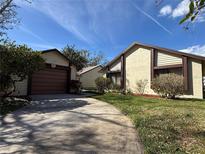 Charming home featuring a long driveway, landscaped yard, and a detached two-car garage at 2230 Sequoia Dr, Clearwater, FL 33763