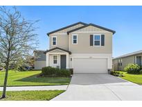 Charming two-story home with a well-maintained lawn and attached two-car garage at 3224 Fresno Pl, Zephyrhills, FL 33541