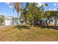 Charming single Gathering home with a tidy front lawn, mature trees, and a detached garage on a sunny day at 3235 34Th N Ave, St Petersburg, FL 33713
