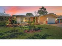 Charming home with a well-maintained lawn and brick garden bed, highlighted by a picturesque sunset sky at 4191 39Th S St, St Petersburg, FL 33711