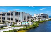 Beautiful beachfront condo complex with a sparkling blue pool and lush landscaping at 6009 Sea Ranch Dr # 307, Hudson, FL 34667