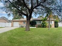 Charming single-story home with a well-manicured lawn, mature trees, and a brick facade at 6315 25Th N Ave, St Petersburg, FL 33710