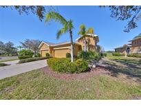 Charming home featuring a two-car garage, well-maintained landscaping, and decorative palm trees at 1154 Jameson Greens N Dr # 20, Sun City Center, FL 33573