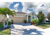 Charming one-story home featuring a two-car garage, a brick paved driveway, and beautifully landscaped yard at 13915 Kingfisher Glen Dr, Lithia, FL 33547