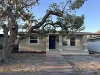 Charming single-story home features a brick facade, front porch, and mature tree in a quiet neighborhood at 3711 1St S Ave, St Petersburg, FL 33711