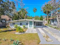 Charming single-story home with a well-manicured lawn, minimalist landscaping, and a modern exterior at 3820 E Lakeshore Dr, Tampa, FL 33604