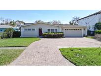 Charming single-story home featuring a brick driveway and a well-manicured front lawn at 547 Suwanee Cir, Tampa, FL 33606