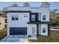 Modern two-story home with a gray garage door and a black and white facade at 7984 Gulf Way, Hudson, FL 34667