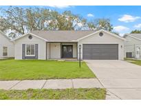Charming single-story home with gray and white exterior paint, attached two-car garage, and well-maintained lawn at 9402 Stonewall Ln, New Port Richey, FL 34655