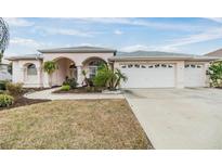 Lovely single-story home with a three car garage, arched entry and mature landscaping at 13941 Talmage Loop, Hudson, FL 34667