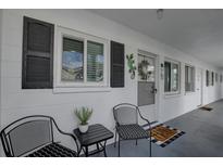 Inviting entrance with chairs and a small table, enhanced by decorative shutters and a charming lizard wall decor at 1546 Pleasant Rd # J1, Bradenton, FL 34207