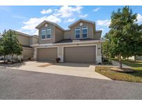 Attractive two-story townhome featuring an attached two-car garage, manicured lawn, and welcoming curb appeal at 1986 Lake Ridge Blvd, Clearwater, FL 33763