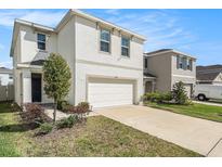 Two-story home features a two-car garage, well-manicured lawn, and tasteful landscaping at 5640 Wandering Willow Dr, Wesley Chapel, FL 33545