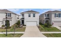 Charming two-story home boasts a well-manicured lawn, large driveway, and an attached two-car garage at 5640 Wandering Willow Dr, Wesley Chapel, FL 33545