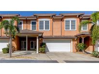 Charming townhouse showcasing a two-car garage, covered entryway, and lush landscaping for enhanced curb appeal at 757 Date Palm Lane, St Petersburg, FL 33707