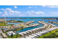 Expansive aerial view of waterfront property featuring a marina, lush landscaping, and stunning ocean views at 1 Boca Ciega Point Blvd # 213, St Petersburg, FL 33708