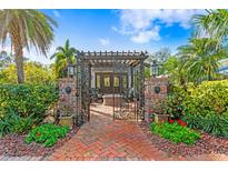 Landscaped courtyard featuring brick pavers, pergola, outdoor seating and an iron gate entry at 101 30Th N Ave, St Petersburg, FL 33704