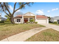 Charming single-story home featuring a well-manicured lawn and a cozy front porch at 13542 Summerwood Ct, Hudson, FL 34667
